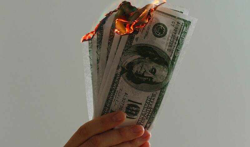 time lapse photography of several burning US dollar banknotes