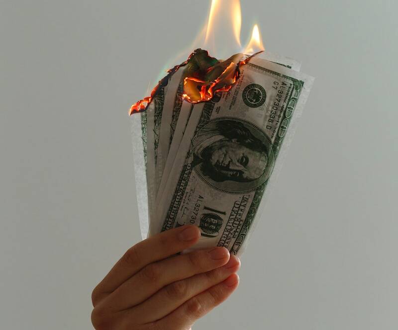 time lapse photography of several burning US dollar banknotes